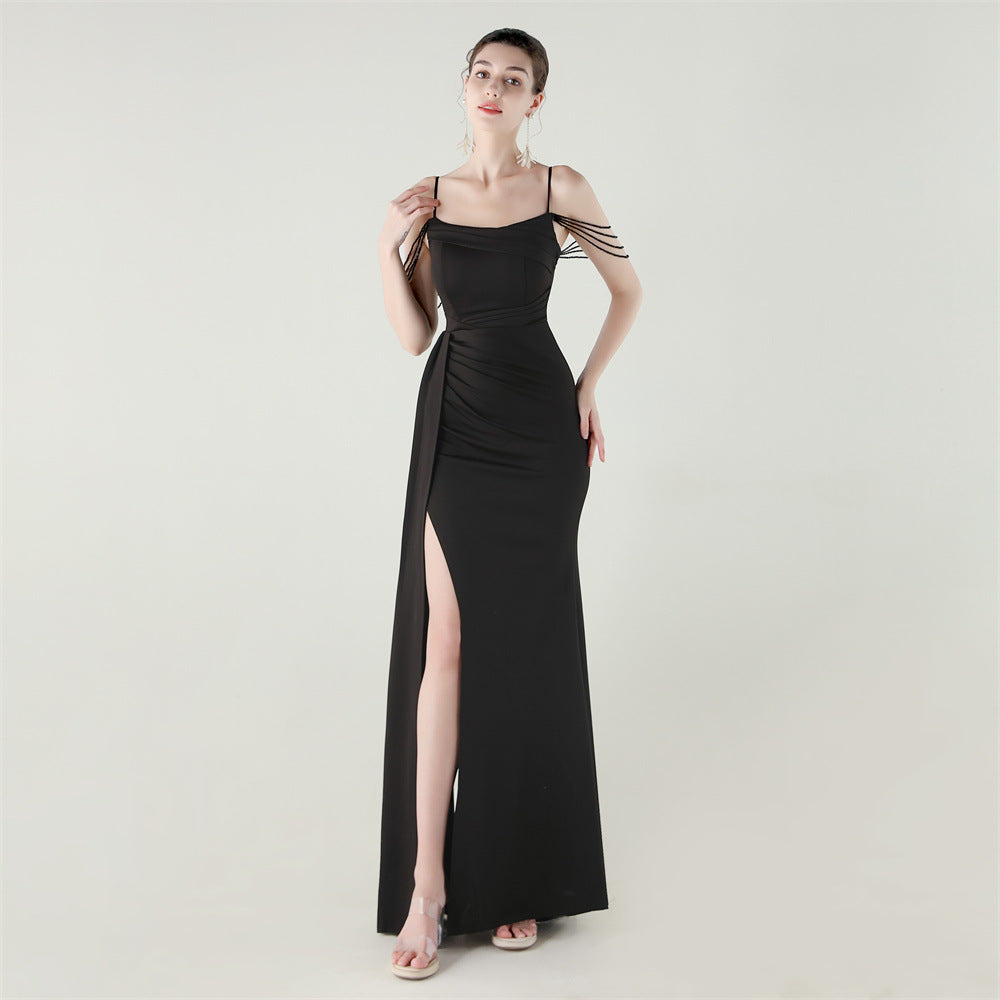 Black satin evening dress with spaghetti straps, beaded fringe detail, and thigh-high slit