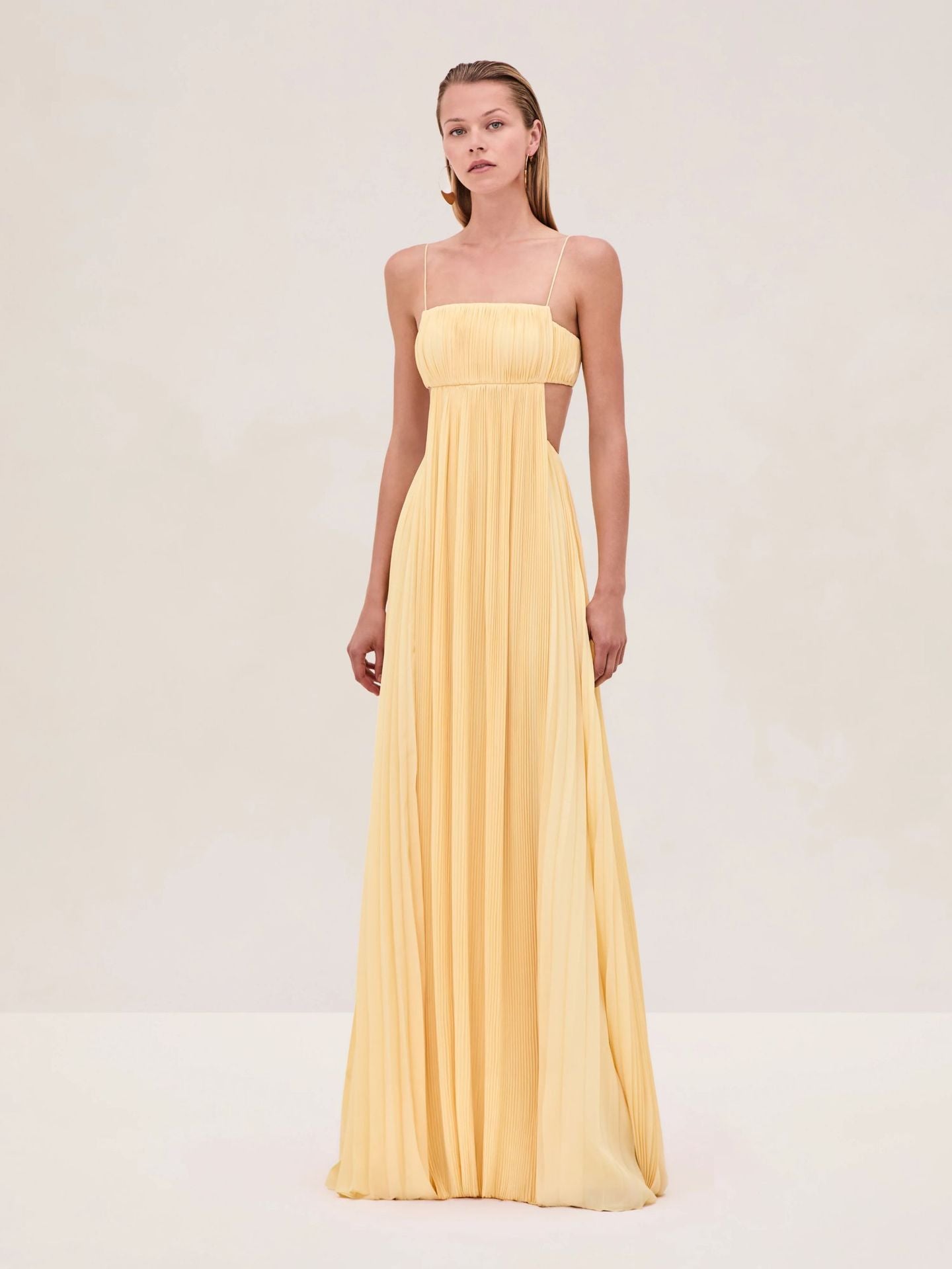 Yellow pleated maxi dress with thin spaghetti straps and fitted bandeau