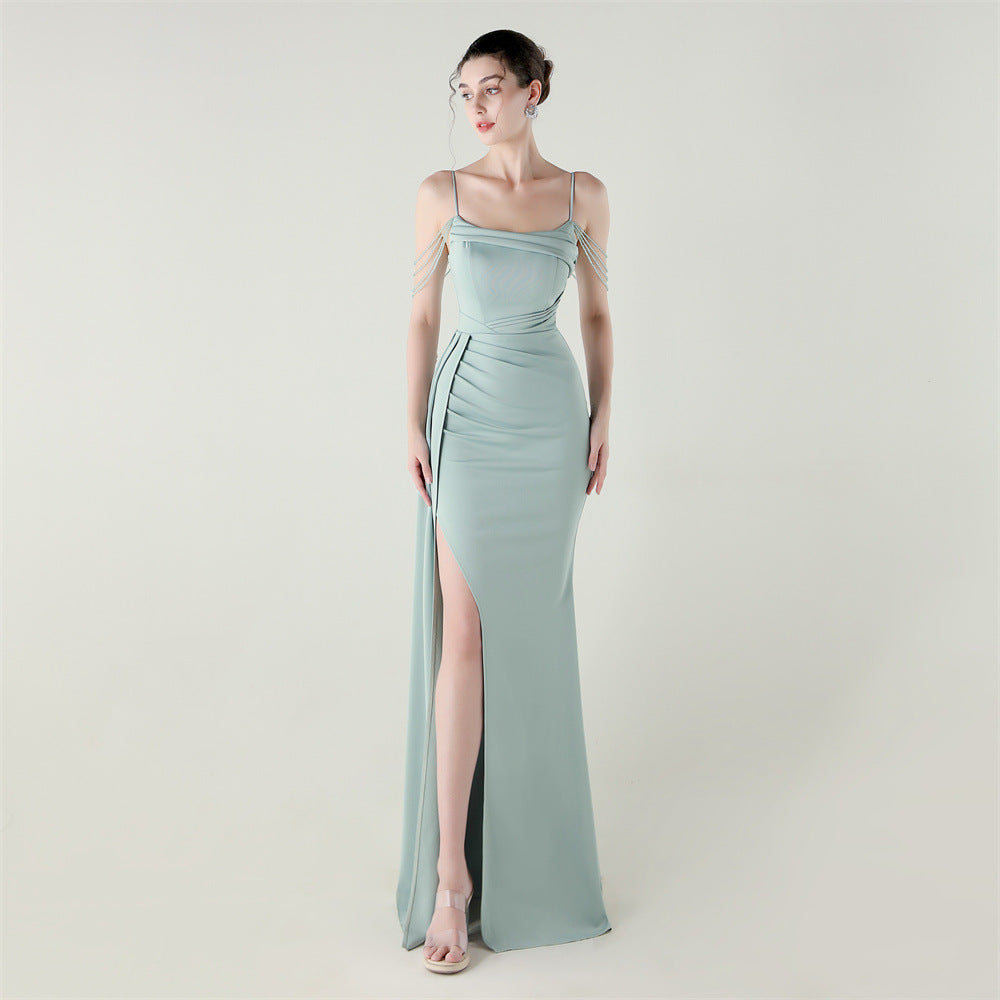 Light green satin evening dress with spaghetti straps, beaded fringe detail, and thigh-high slit