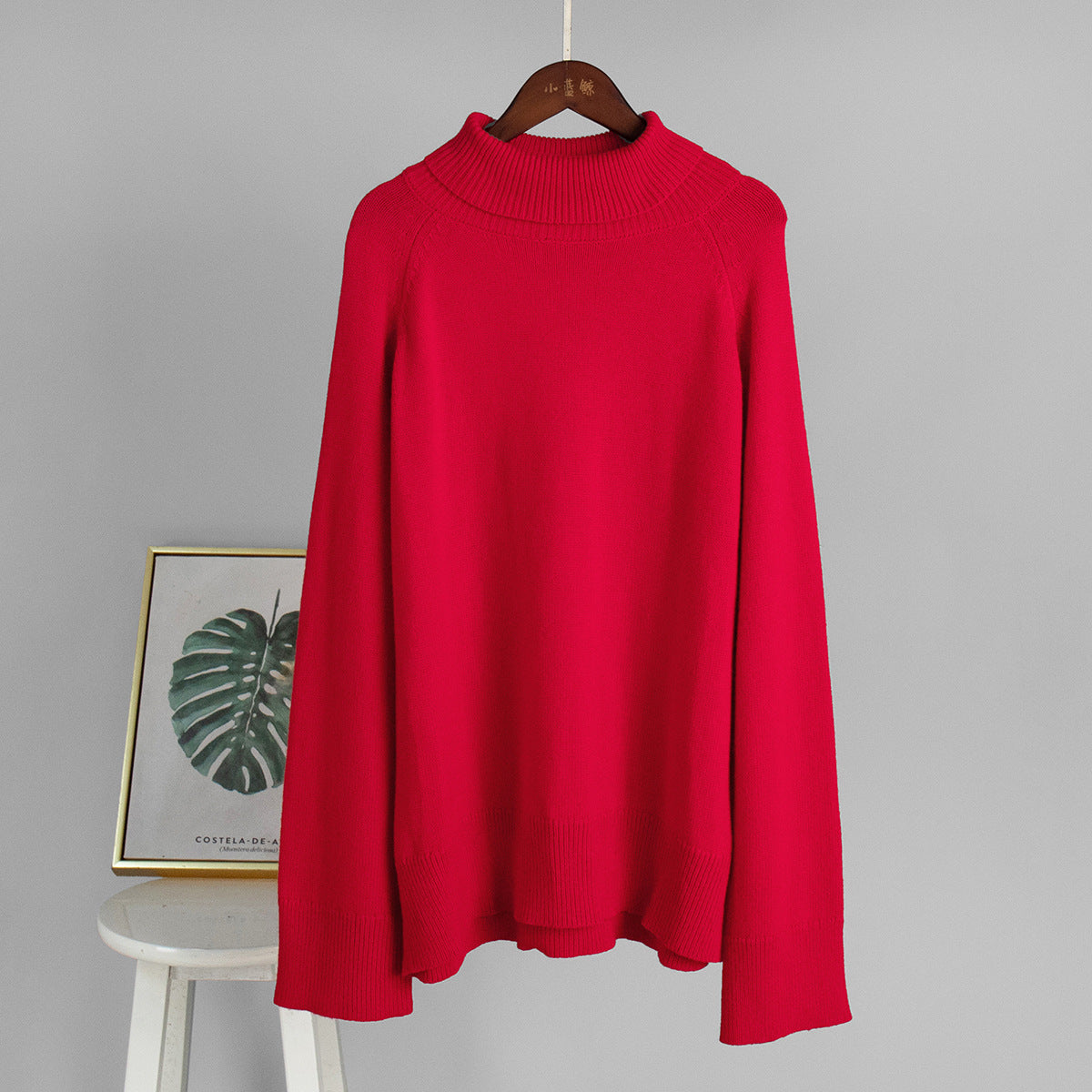 Red turtleneck sweater on hanger with ribbed neck and hem