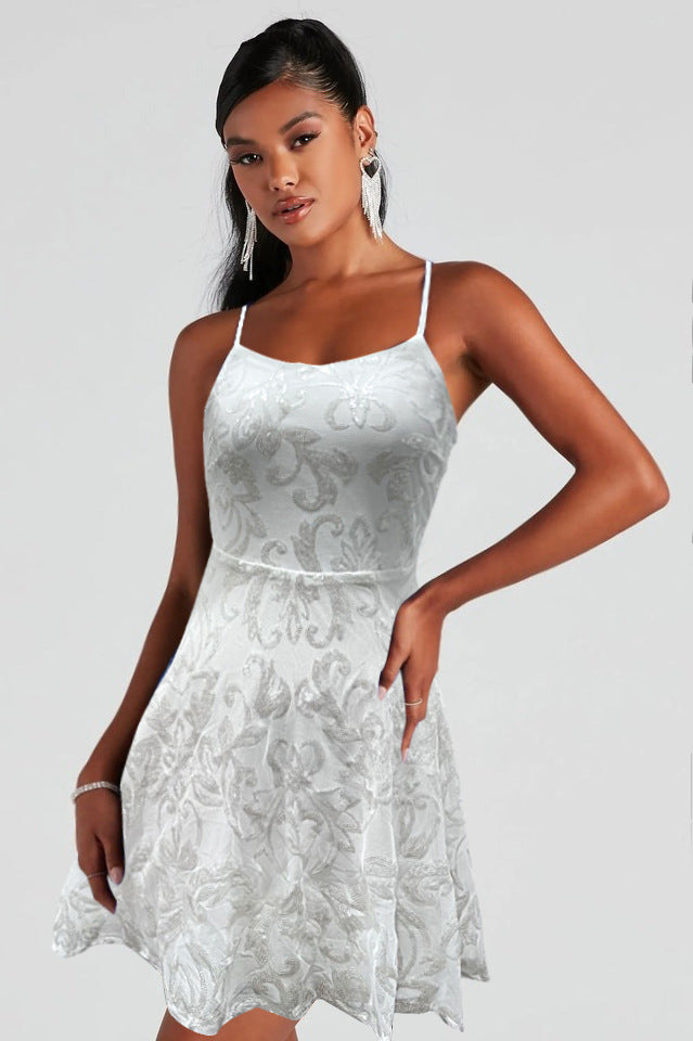 White sequin mini dress with spaghetti straps and flared A-line skirt.