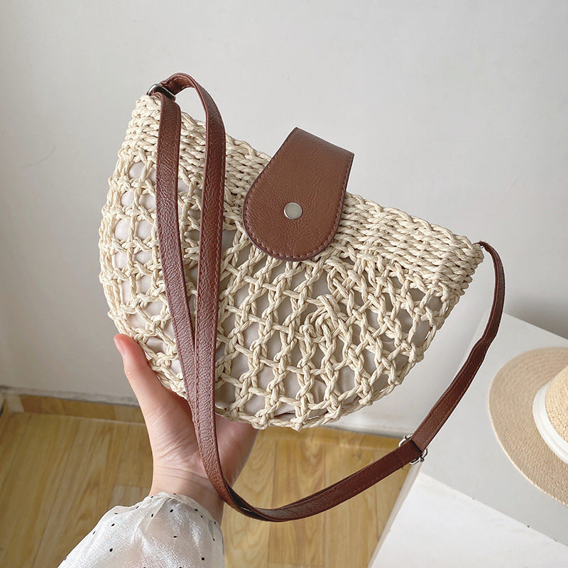 Woven straw semicircle shoulder bag with brown leather snap flap and crossbody strap