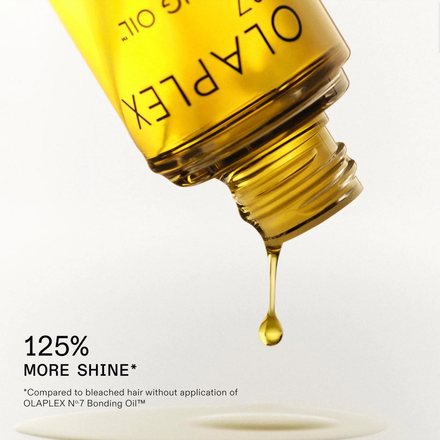 Olaplex No. 7 Bonding Oil golden drop being dispensed from bottle spout