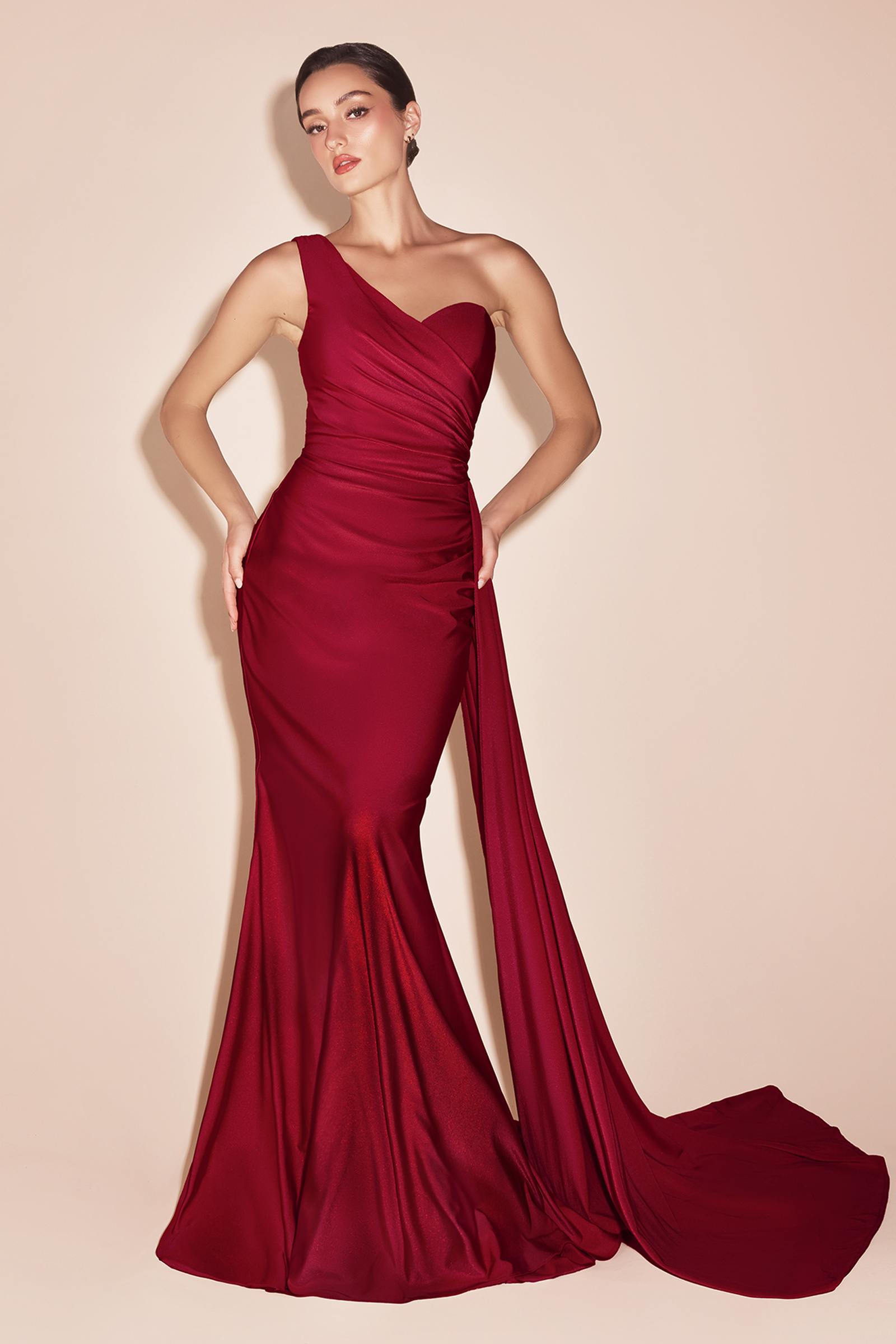 One-shoulder satin gown in deep red with gathered waist and draped side sash, long skirt