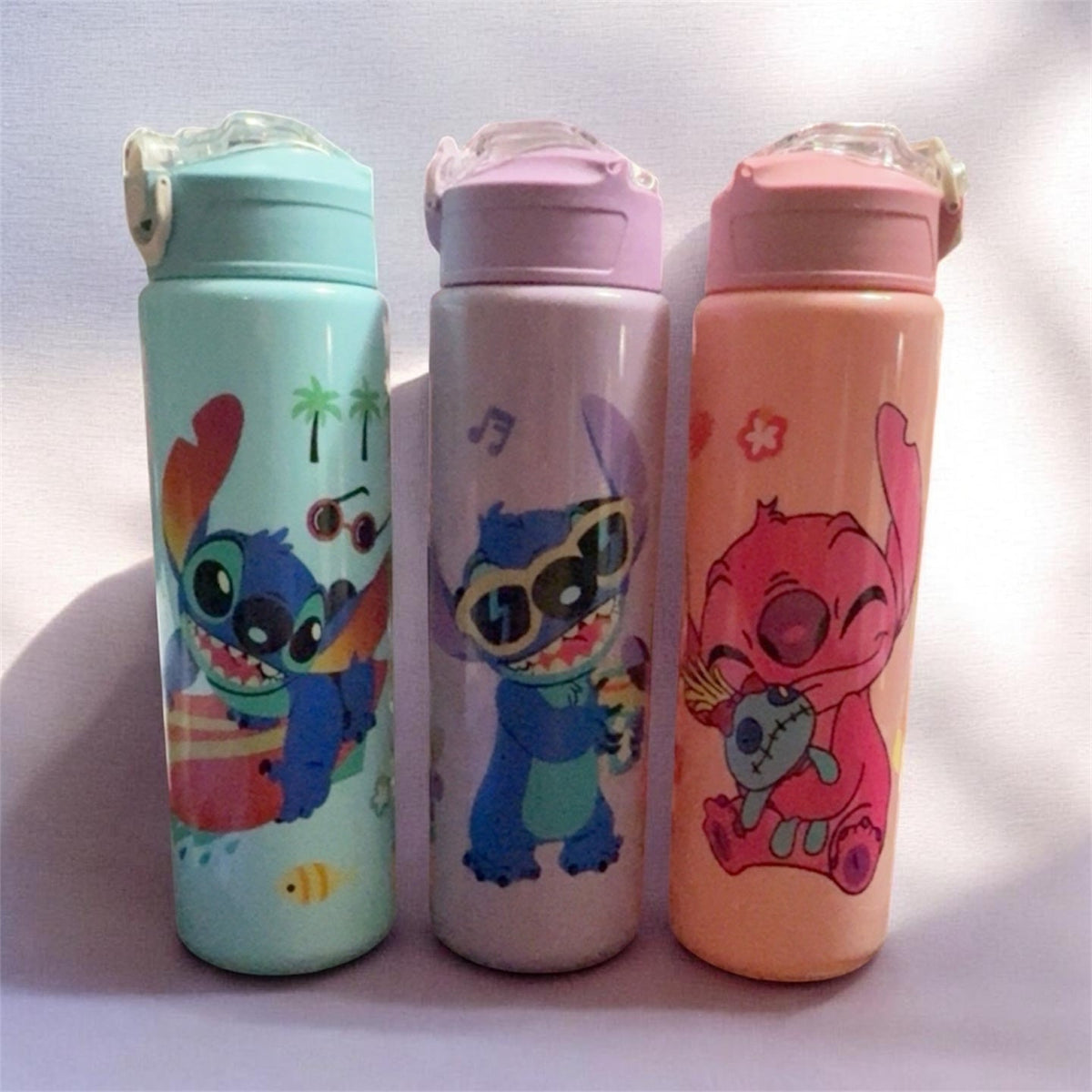 Three pastel character drink tumblers with flip-top lids: mint, purple, and coral.