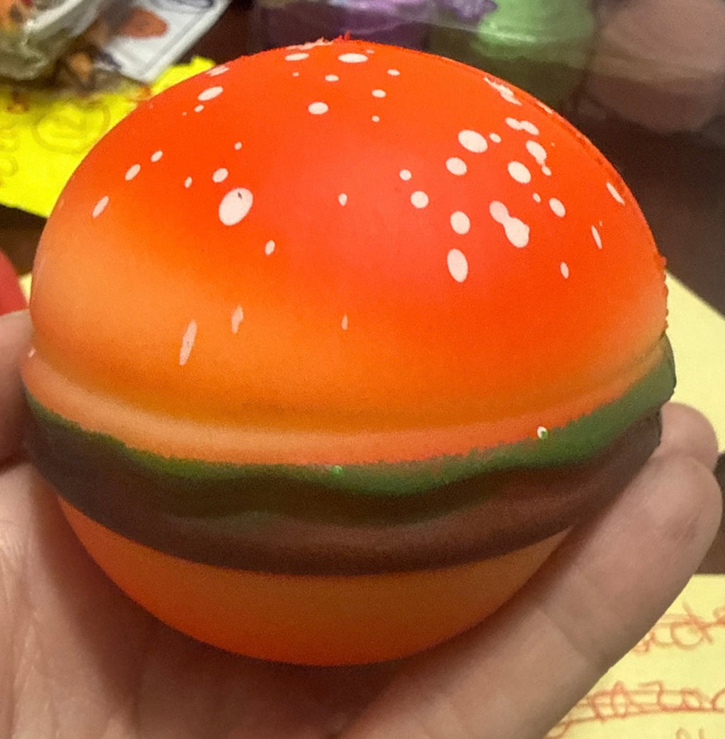 Squishy hamburger stress toy, orange bun with white speckles and green lettuce