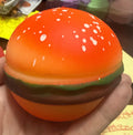 Squishy hamburger stress toy, orange bun with white speckles and green lettuce