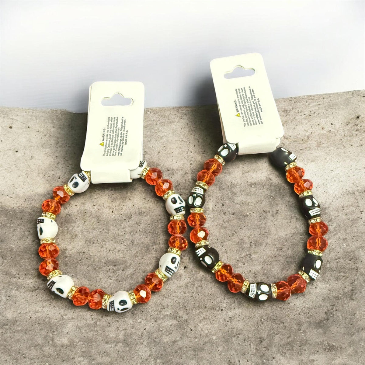 Skull bead stretch bracelet with amber orange glass beads and white skull charms