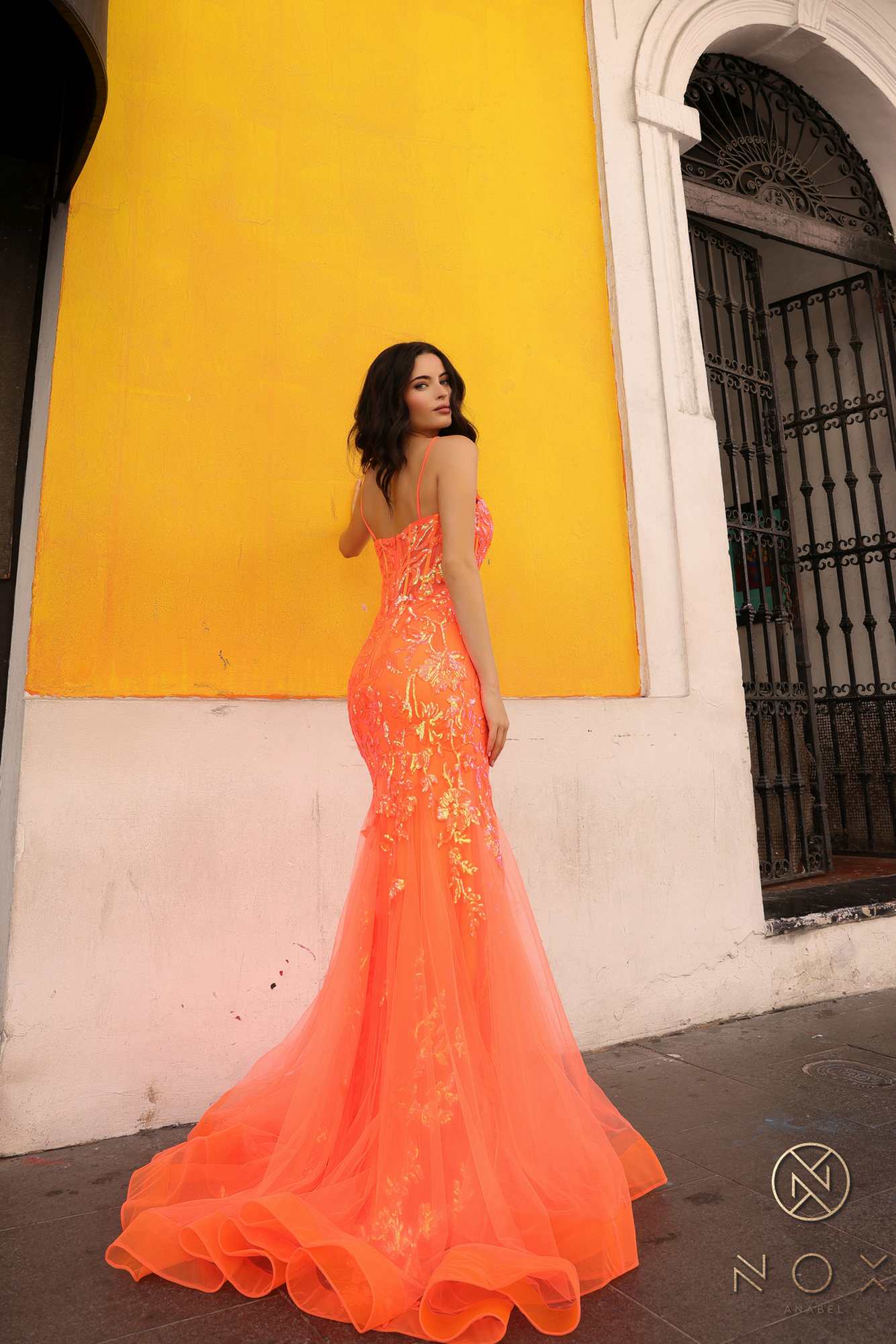 Coral orange sequin applique trumpet gown from back with low back and flared skirt
