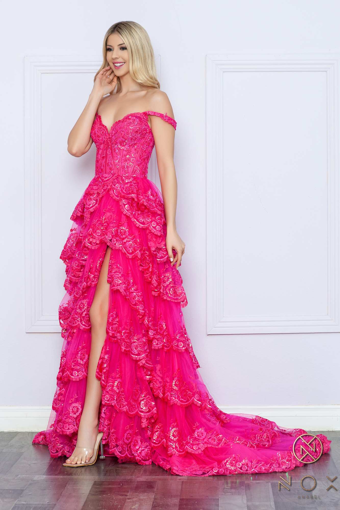 Long off-the-shoulder tiered A-line formal gown in fuchsia pink, angled view