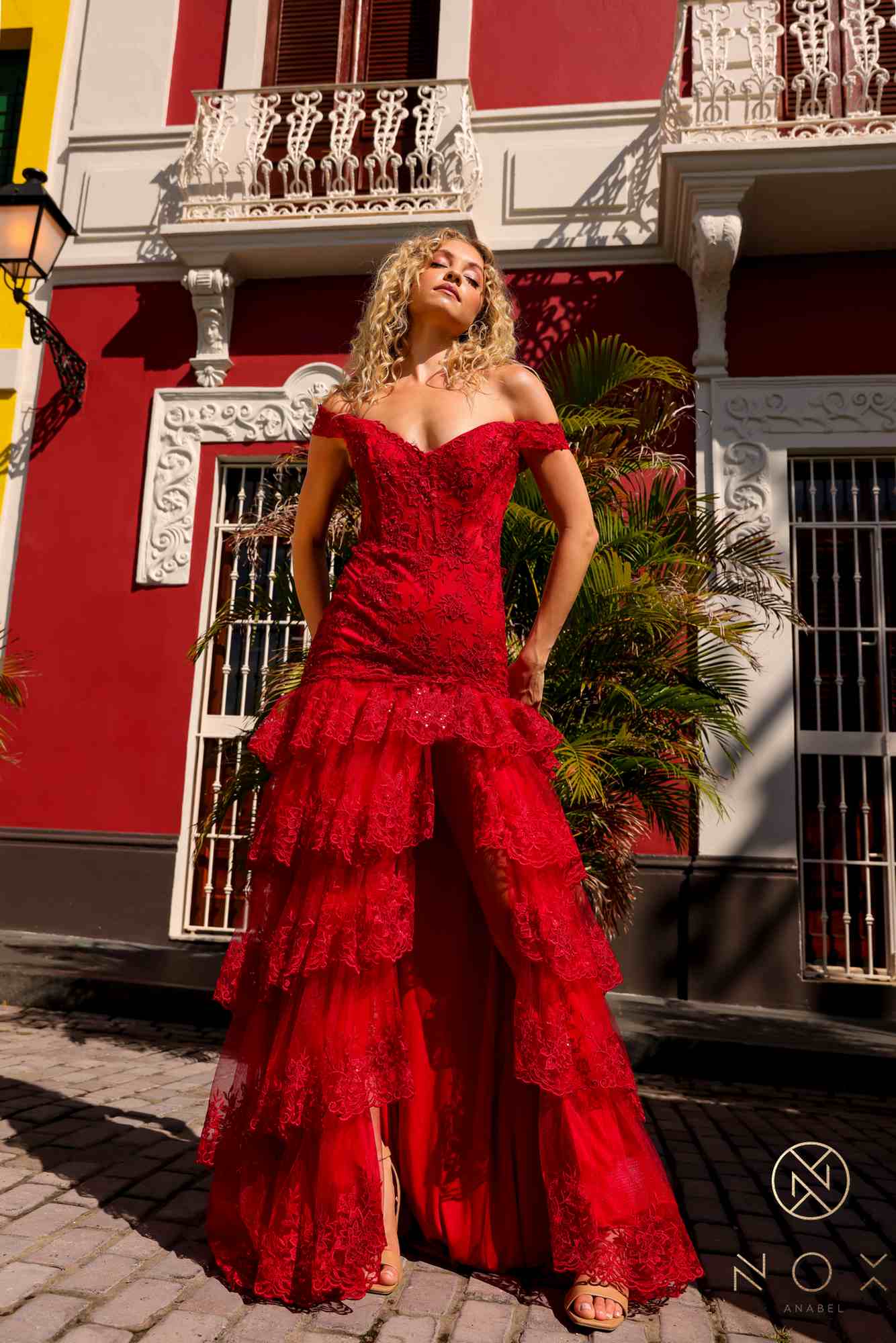 Red off-shoulder corset dress with layered ruffle tiers and long flowing hem.