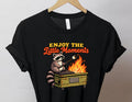 Black graphic tee with Enjoy the Little Moments text and raccoon flame illustration