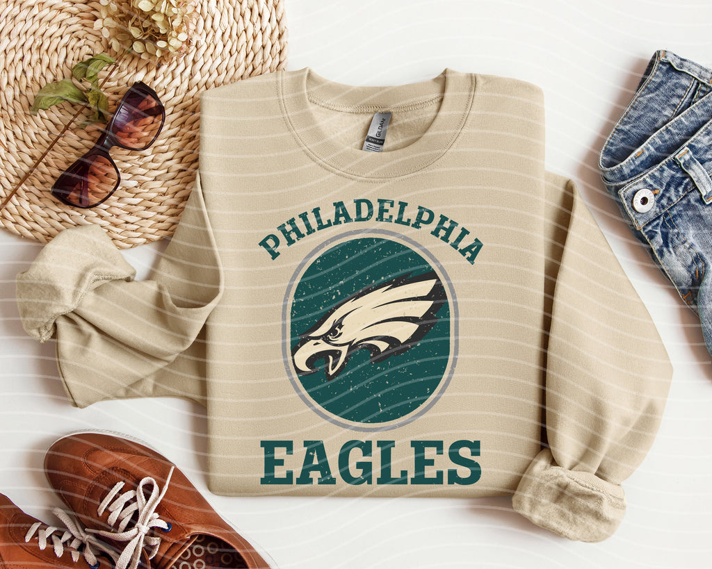 Cream graphic tee with large retro eagle seal, PHILADELPHIA above EAGLES on front