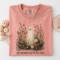 Light pink crewneck graphic tee with floral scene and large ghost illustration text