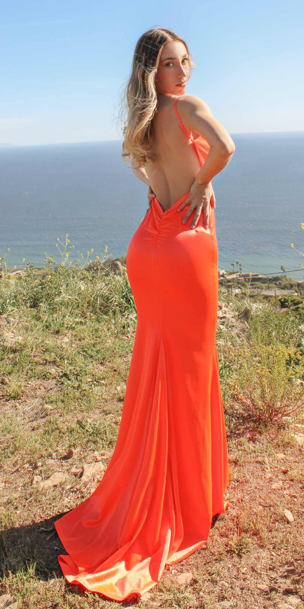 Orange long fitted gown with thin straps and flowing mermaid hem