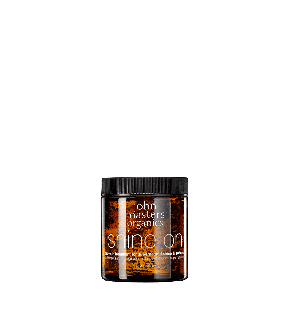 Leave-in hair treatment bottle with amber liquid, black cap, Shine On label