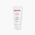 Skincode brightening hand cream tube, white with red logo and cap.