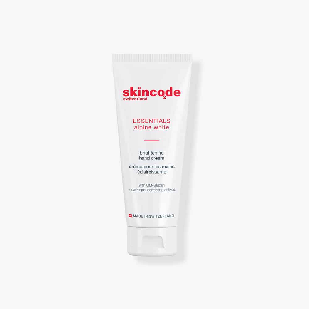 Skincode brightening hand cream tube, white with red logo and cap.