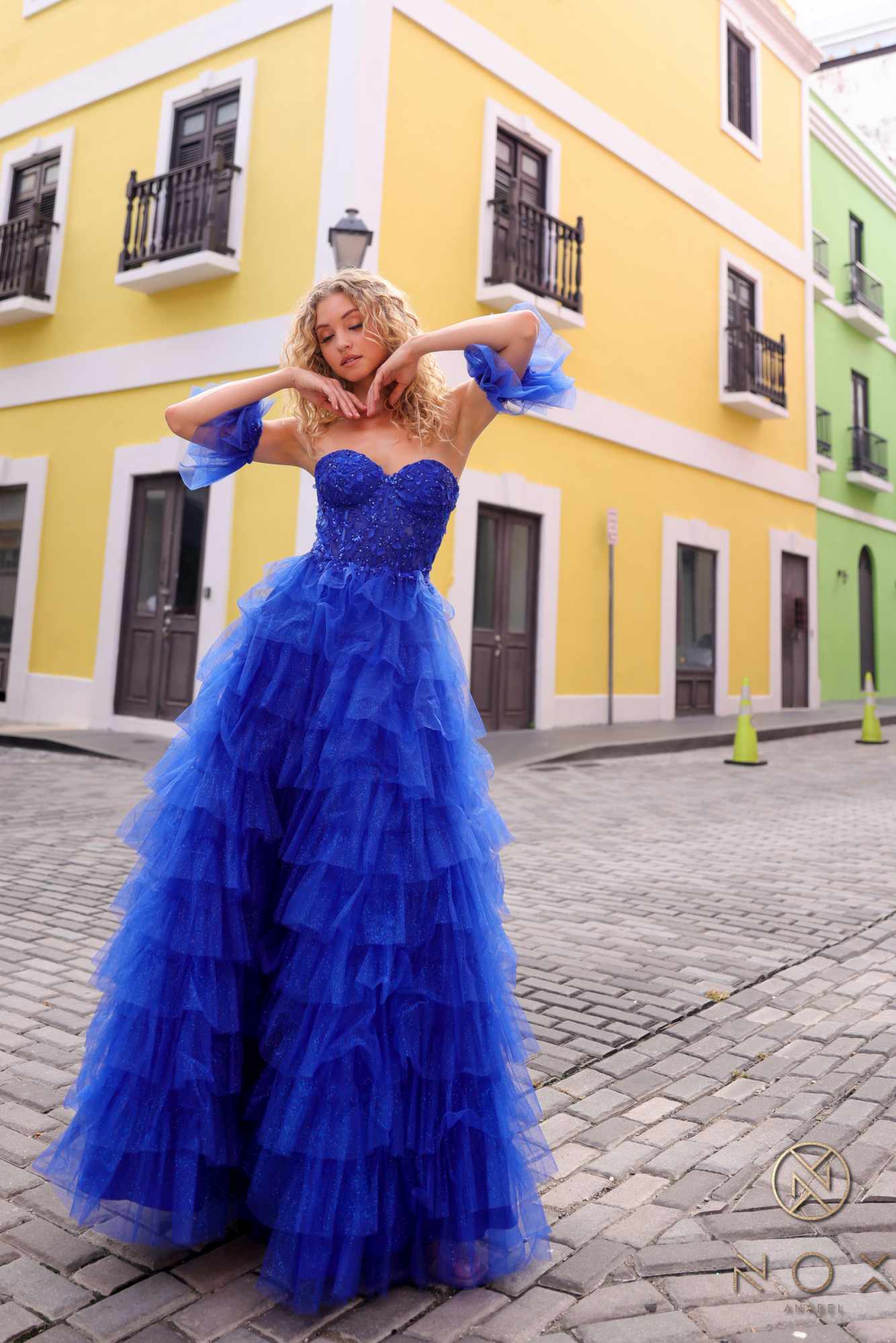 Royal blue long tiered A-line ball gown with ruffled sweetheart bodice and sheer arm cuffs