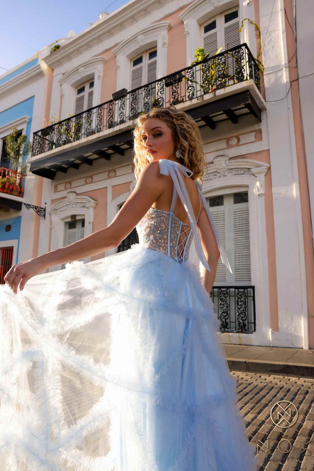 Light blue ruffled tulle A-line gown with corset-style bodice and spaghetti straps