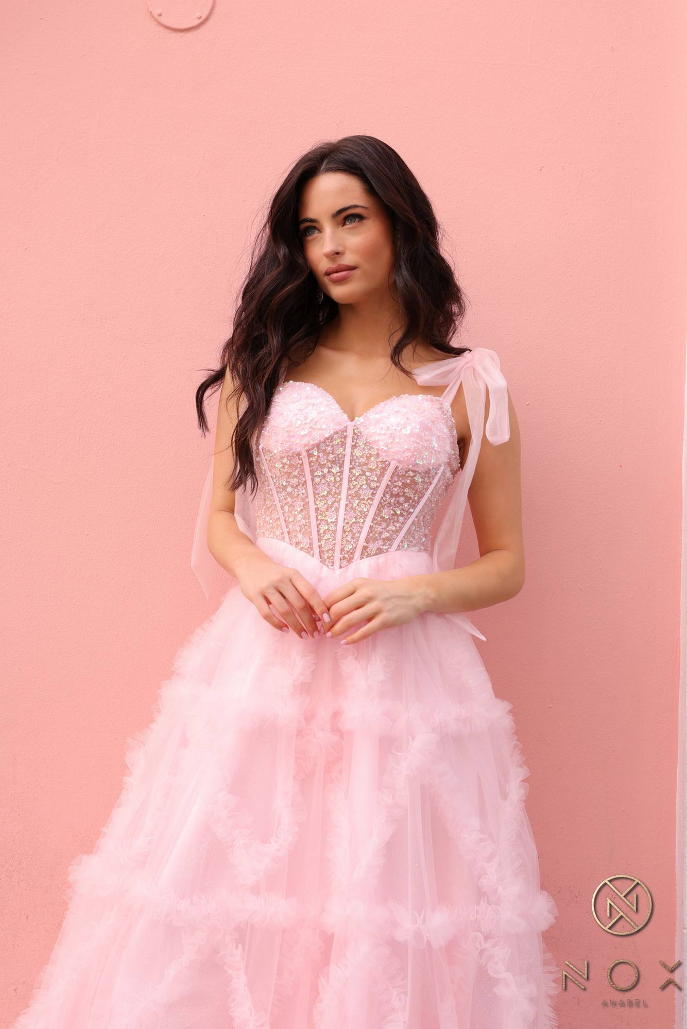 Blush pink corset-style bodice and ribbon straps with tiered ruffled tulle skirt