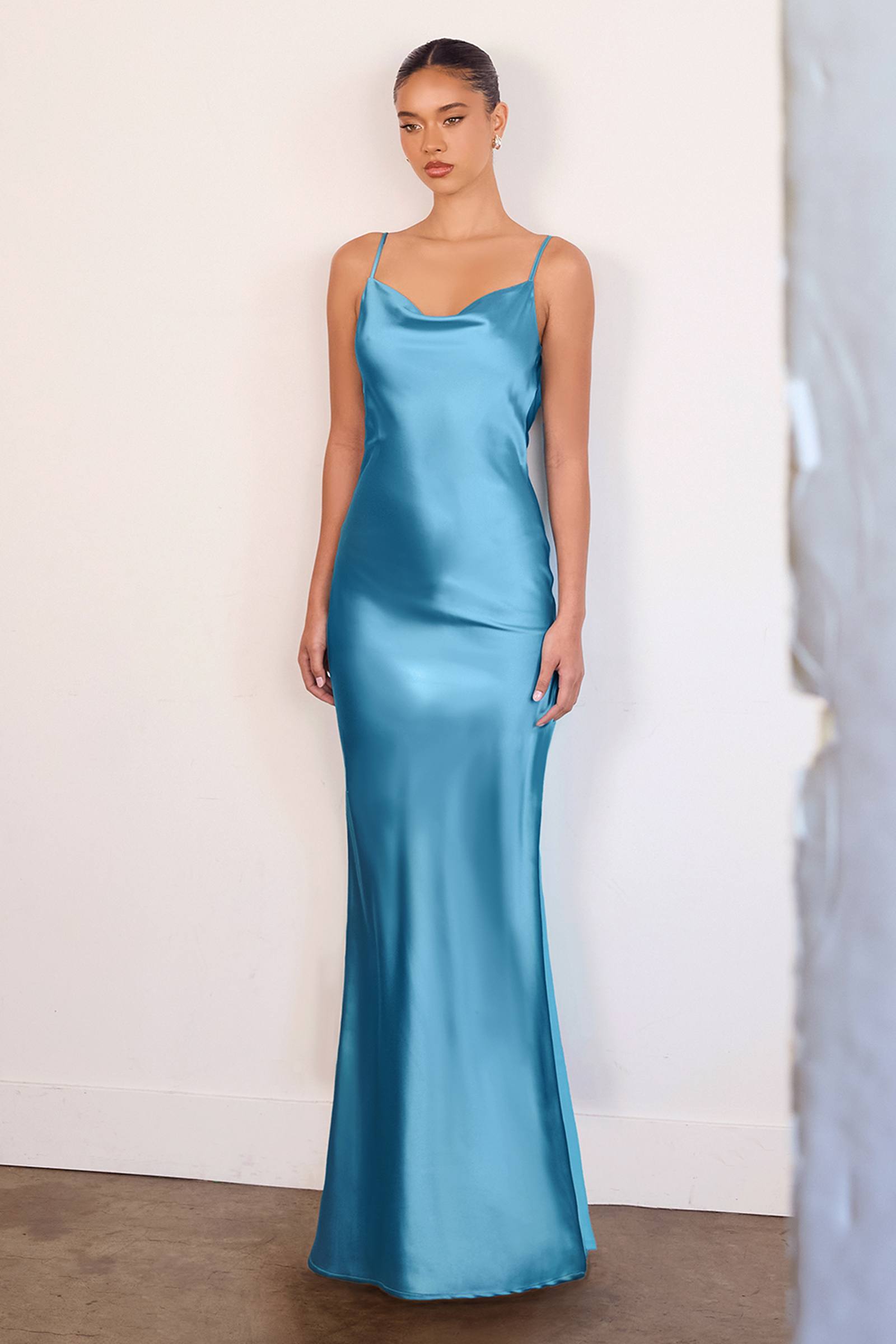 Sleeveless satin gown in light blue with thin straps, fitted bodice and long skirt.