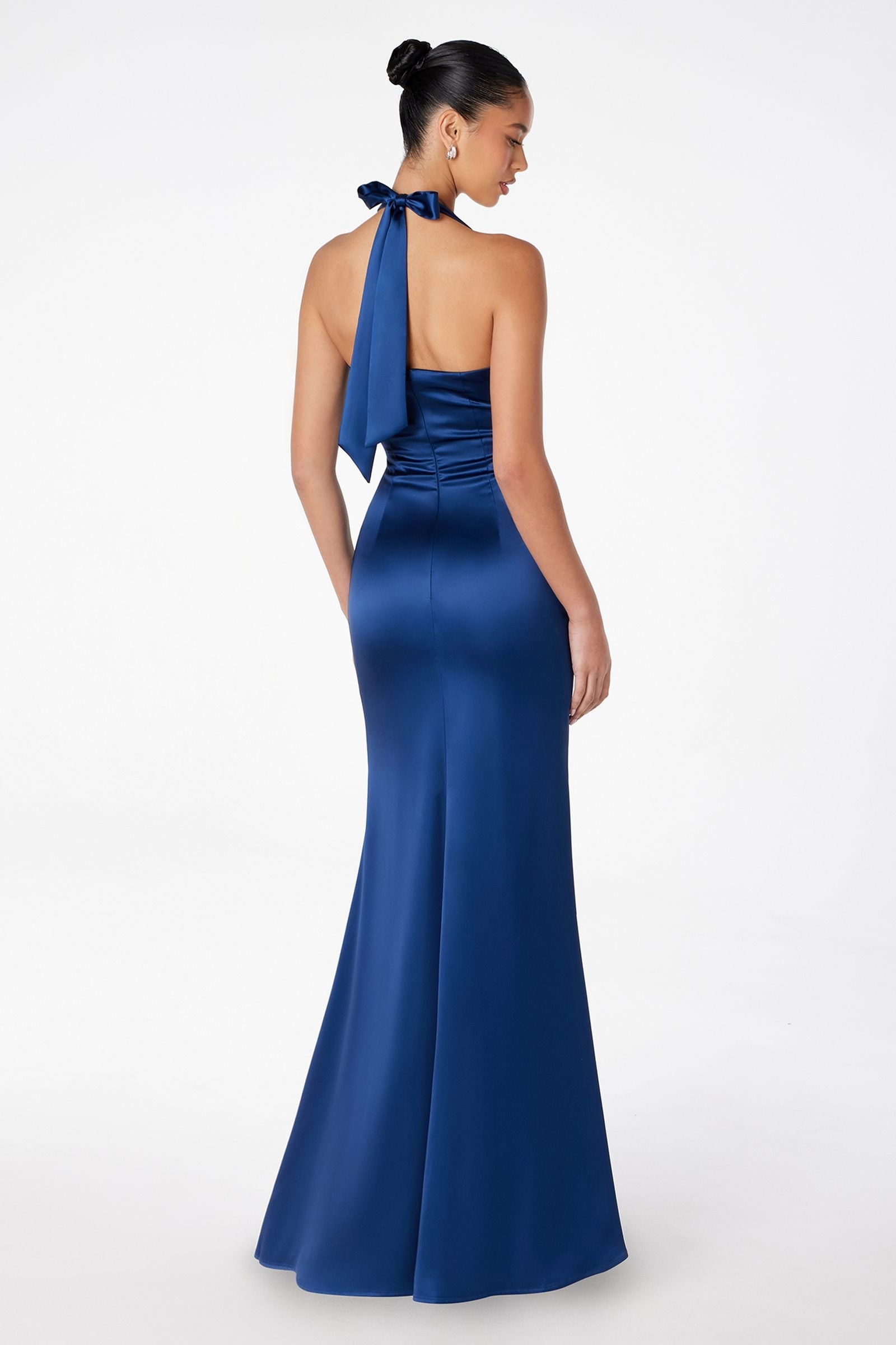 Blue satin halter gown with open back and bow tie detail, long fitted skirt