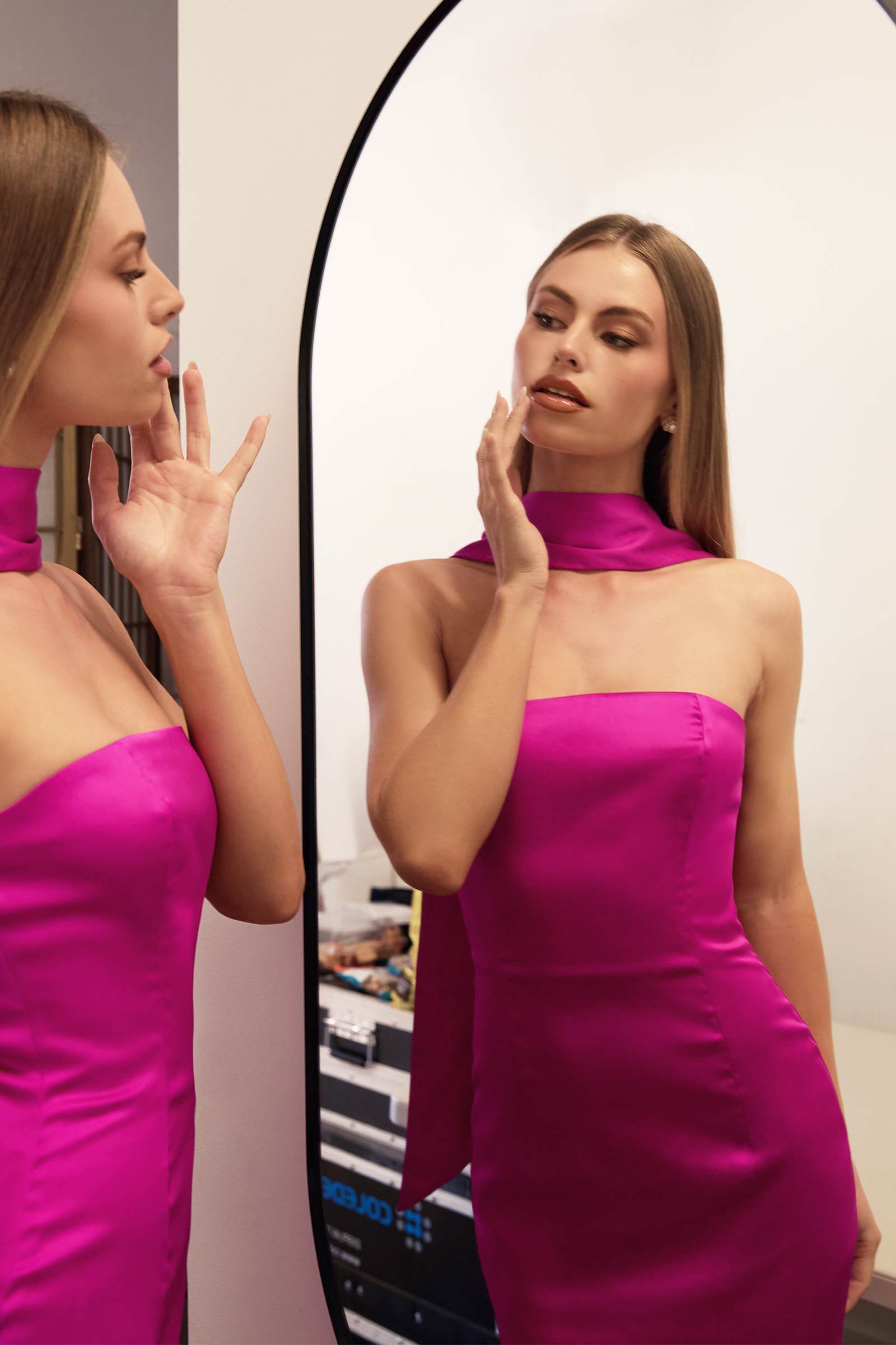 Hot pink strapless fitted mermaid gown with draped neck scarf, mirrored side view
