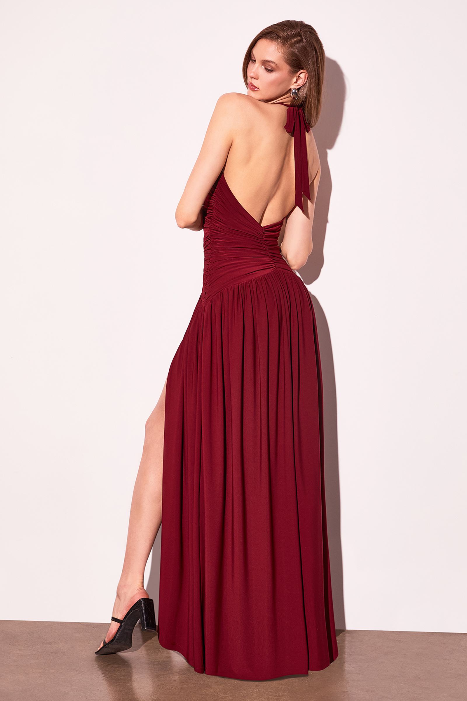Burgundy halter V-neck evening gown with ruched fabric and side leg slit