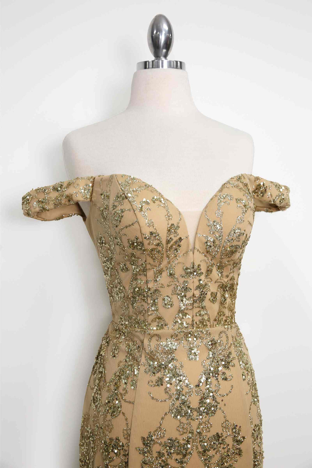 Gold off-shoulder sequin lace fitted bodice gown on mannequin, close-up