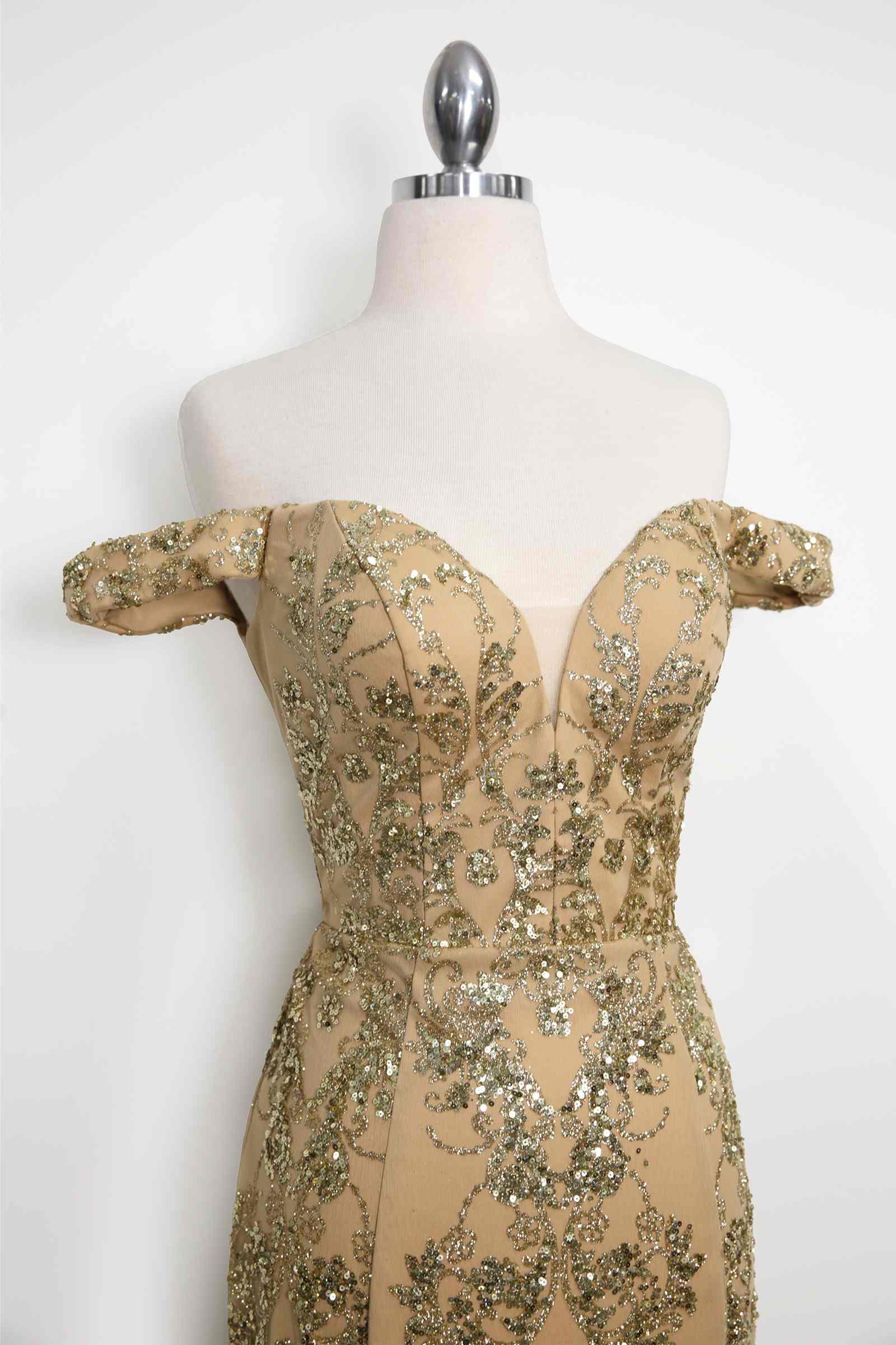 Gold off-shoulder sequin lace fitted bodice gown on mannequin, close-up