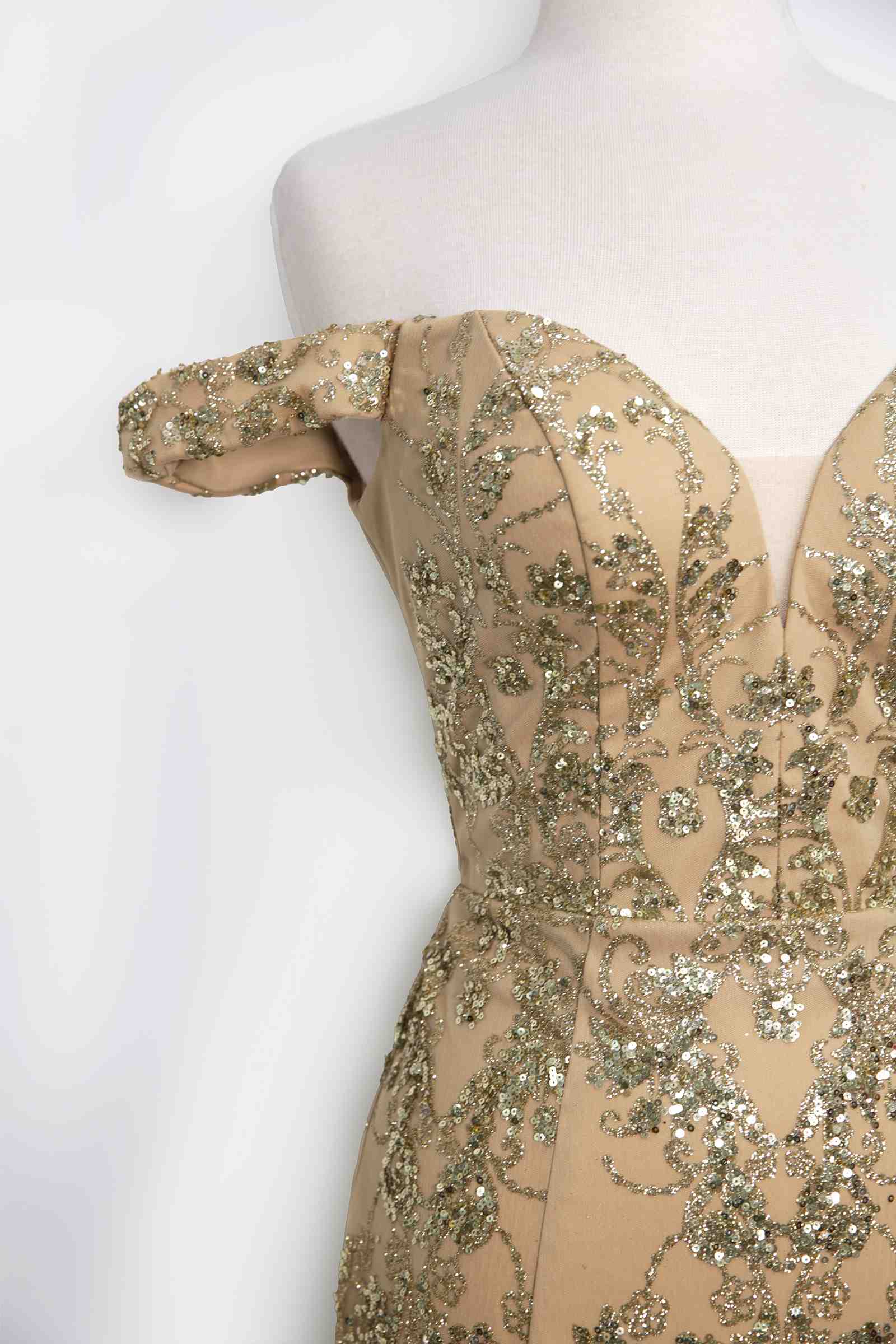 Gold sequin lace off-shoulder fitted gown bodice detail on mannequin