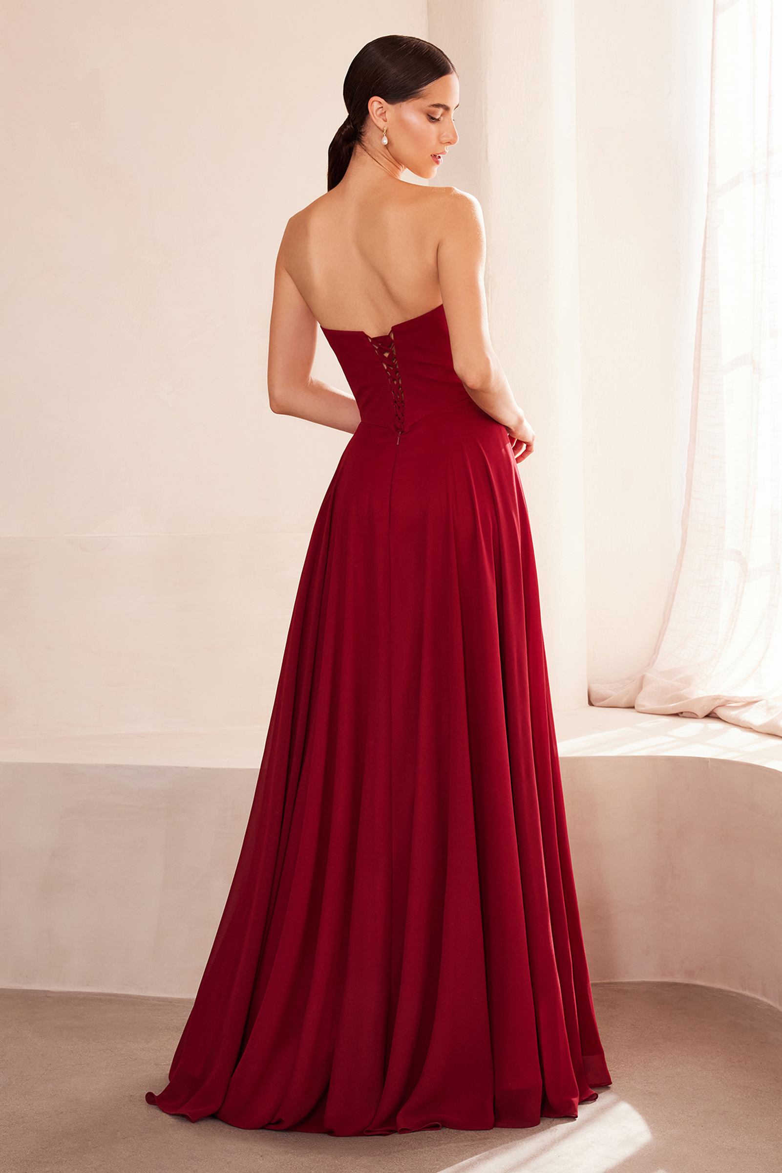 Strapless A-line bridesmaid dress in burgundy with open back and flowing pleated skirt