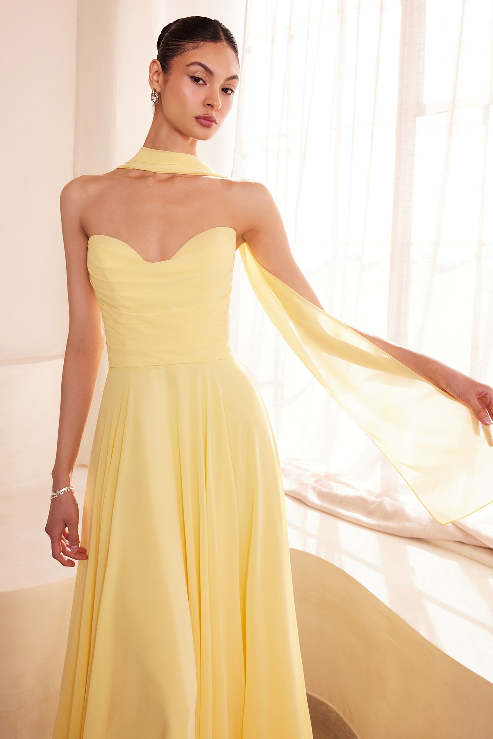 Light yellow strapless A-line bridesmaid dress with sweetheart neckline and flowing cape-like sleeve