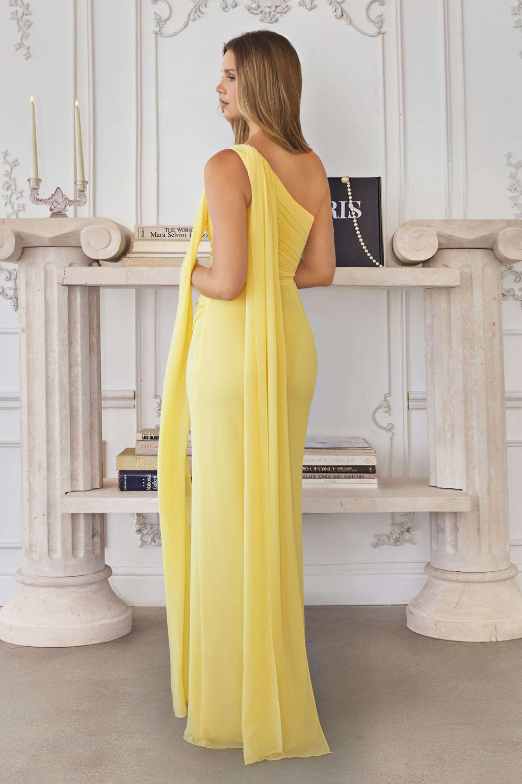 Yellow one-shoulder chiffon formal gown with back sash detail and long chiffon skirt.