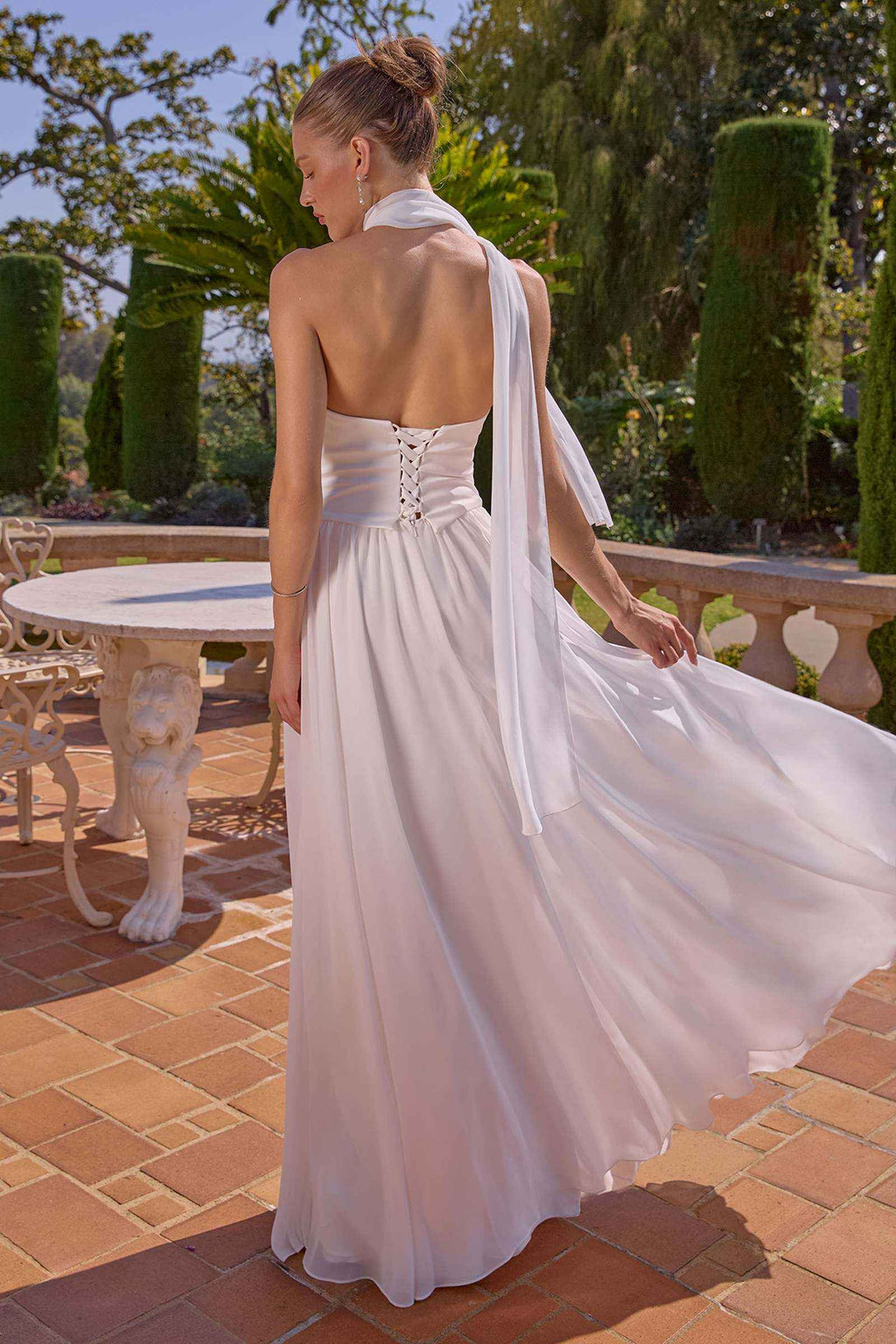 Off-white strapless A-line evening gown with open back and flowing sash