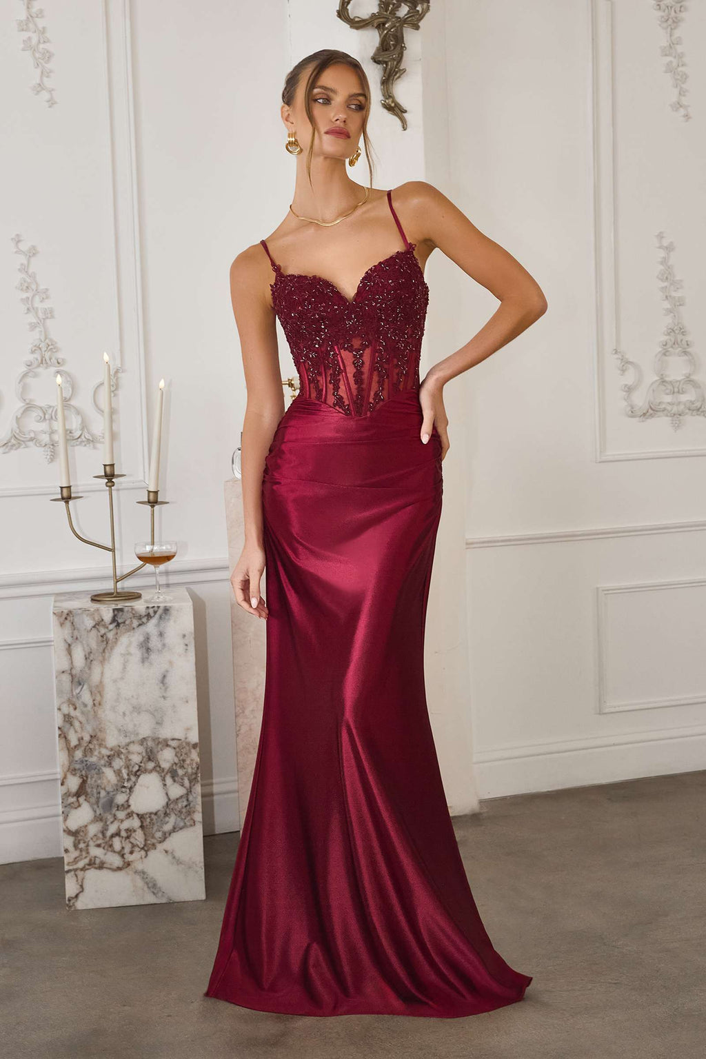Burgundy fitted satin mermaid gown with beaded corset bodice and thin straps.