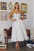 Off-white strapless midi wedding gown with fitted bodice and flared skirt
