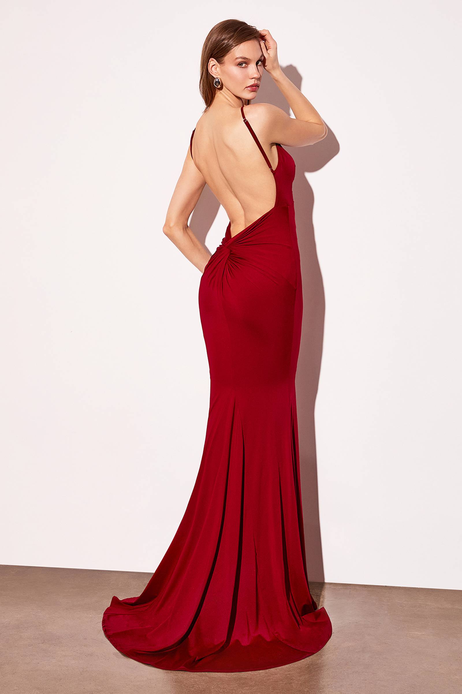 Burgundy fitted evening gown with V-neckline, thin straps, and open back