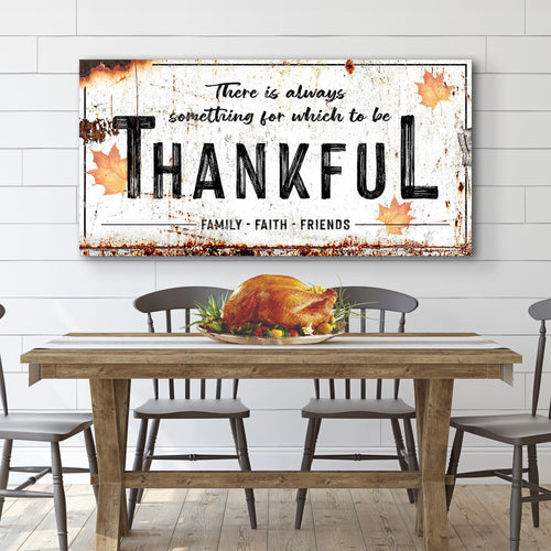 Thankful wall sign with distressed white background, black lettering, autumn splashes