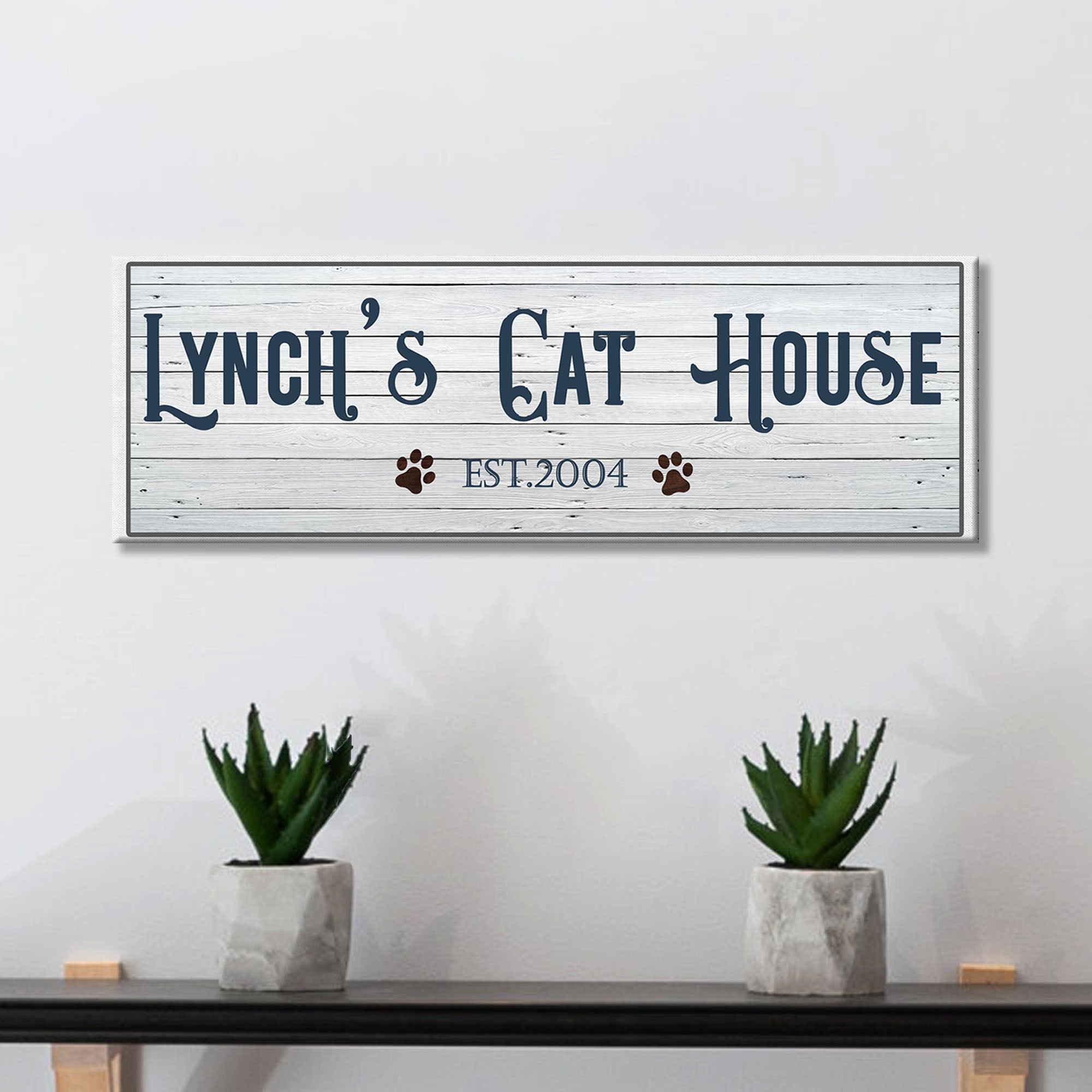 Framed canvas sign reading "Lynch's Cat House" with paw icons and EST.2004