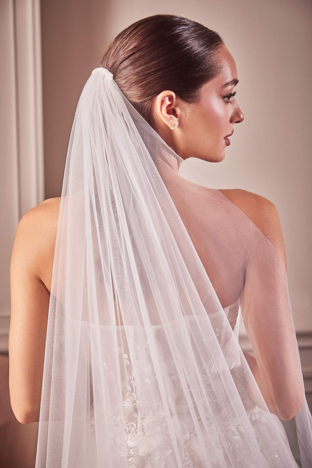 Off-white tulle chapel veil with lace appliqué along the edge, worn over shoulders