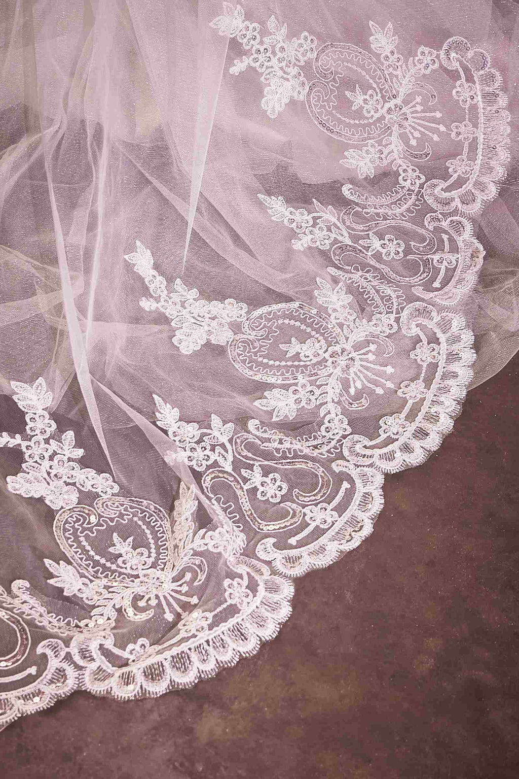 Off-white lace edge on a chapel veil with ornate floral embroidery pattern
