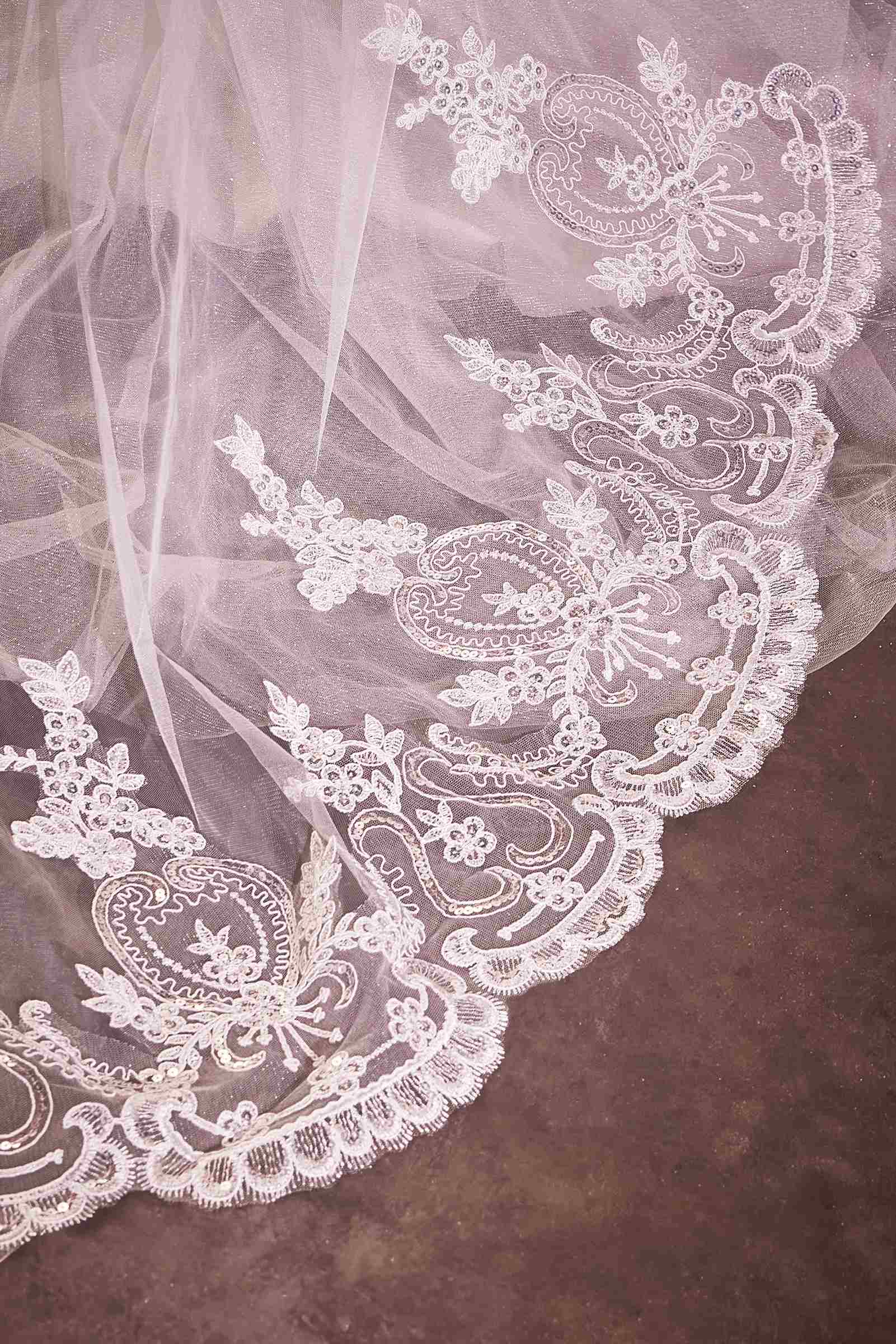 Off-white lace edge on a chapel veil with ornate floral embroidery pattern