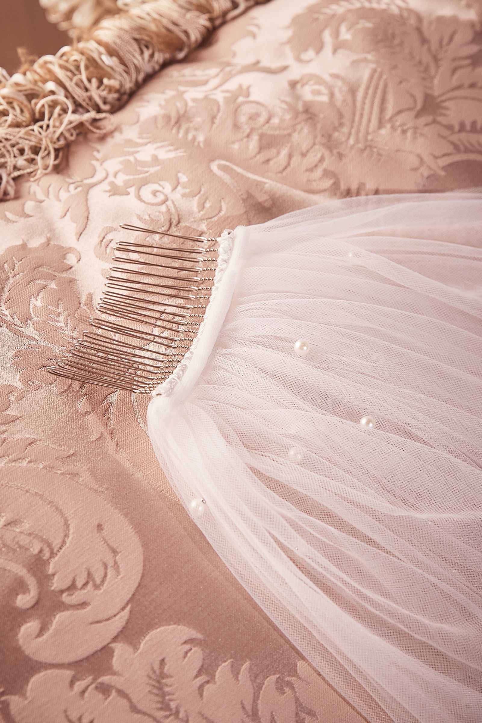 Off-white tulle chapel veil with pearl-like beads and comb attachment