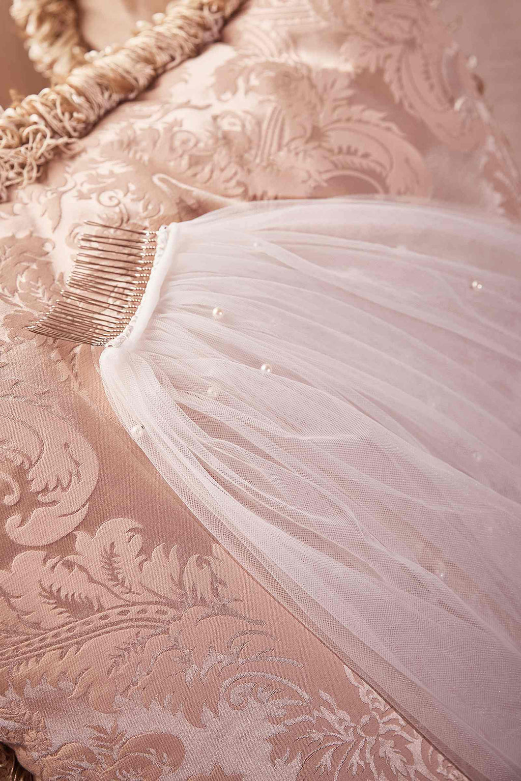 Off-white tulle veil with pearl accents along the edge