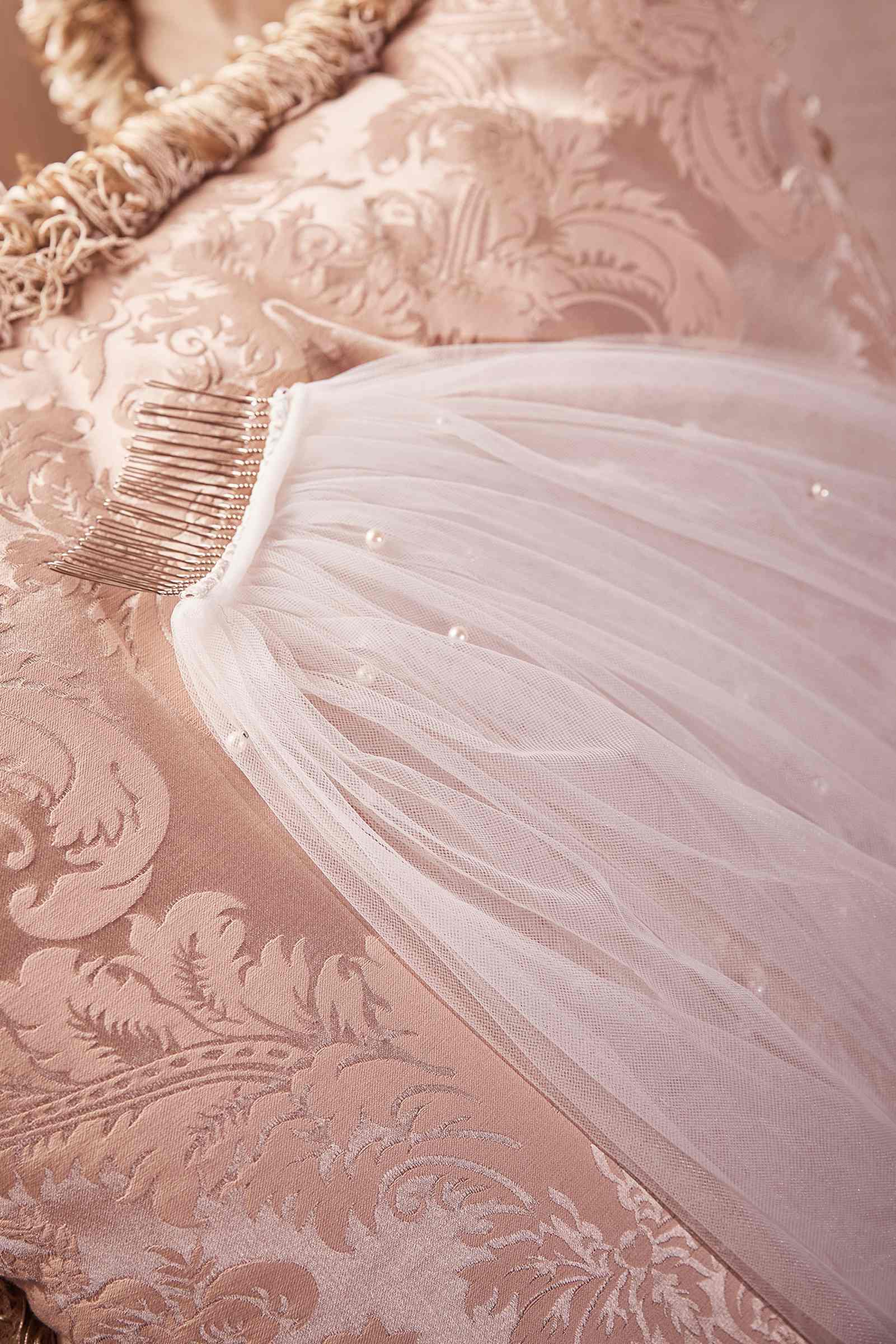 Off-white tulle veil with pearl accents along the edge