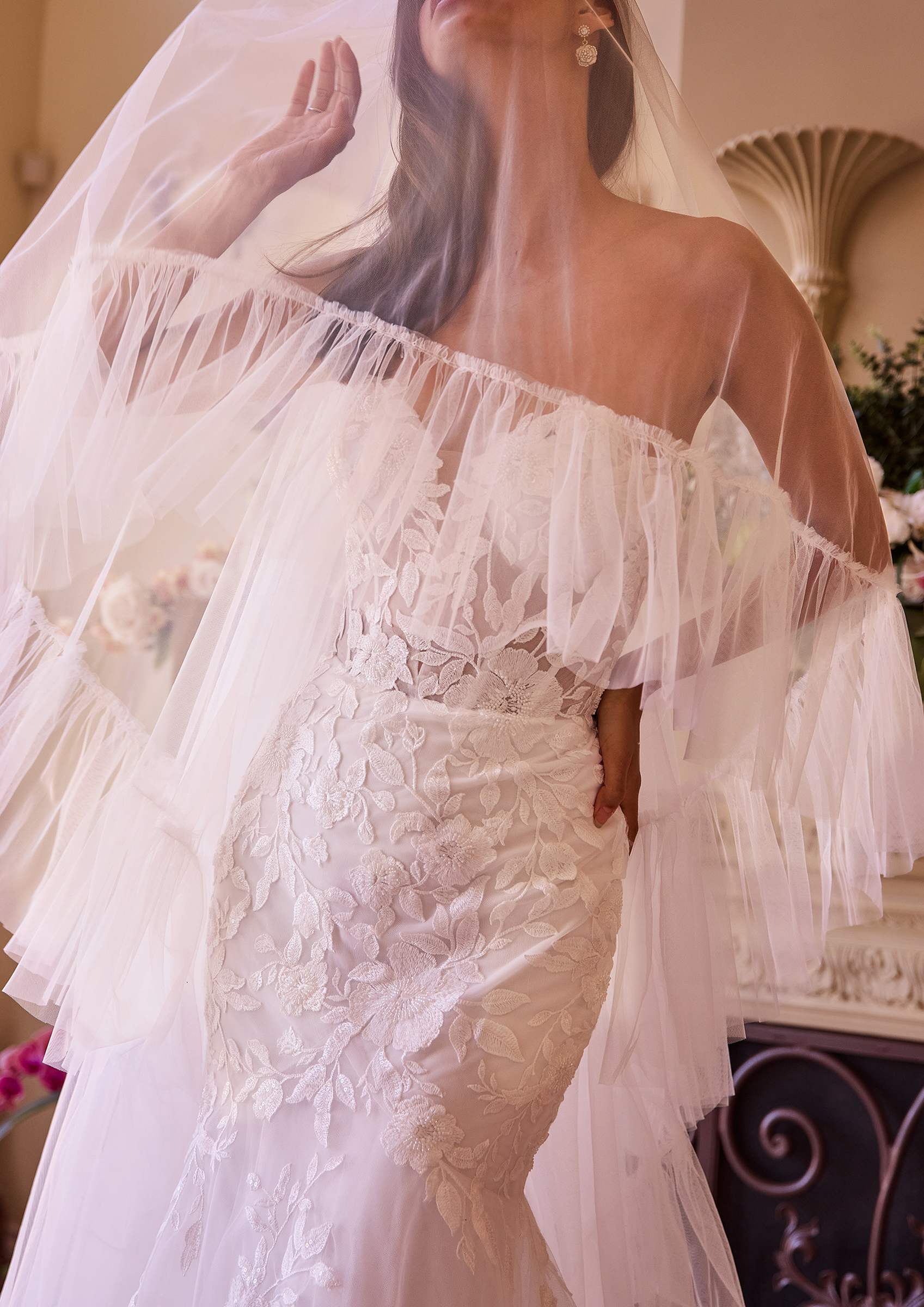 Off-white ruffle-edge two-tier veil framing the off-shoulder lace bodice