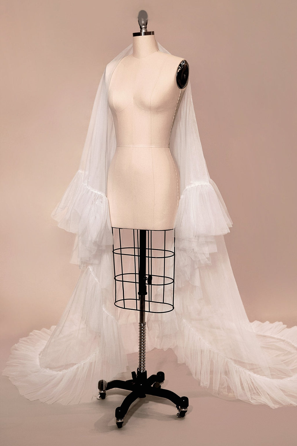 Off-white two-tier ruffle-edge bridal veil on a dress form, full drape