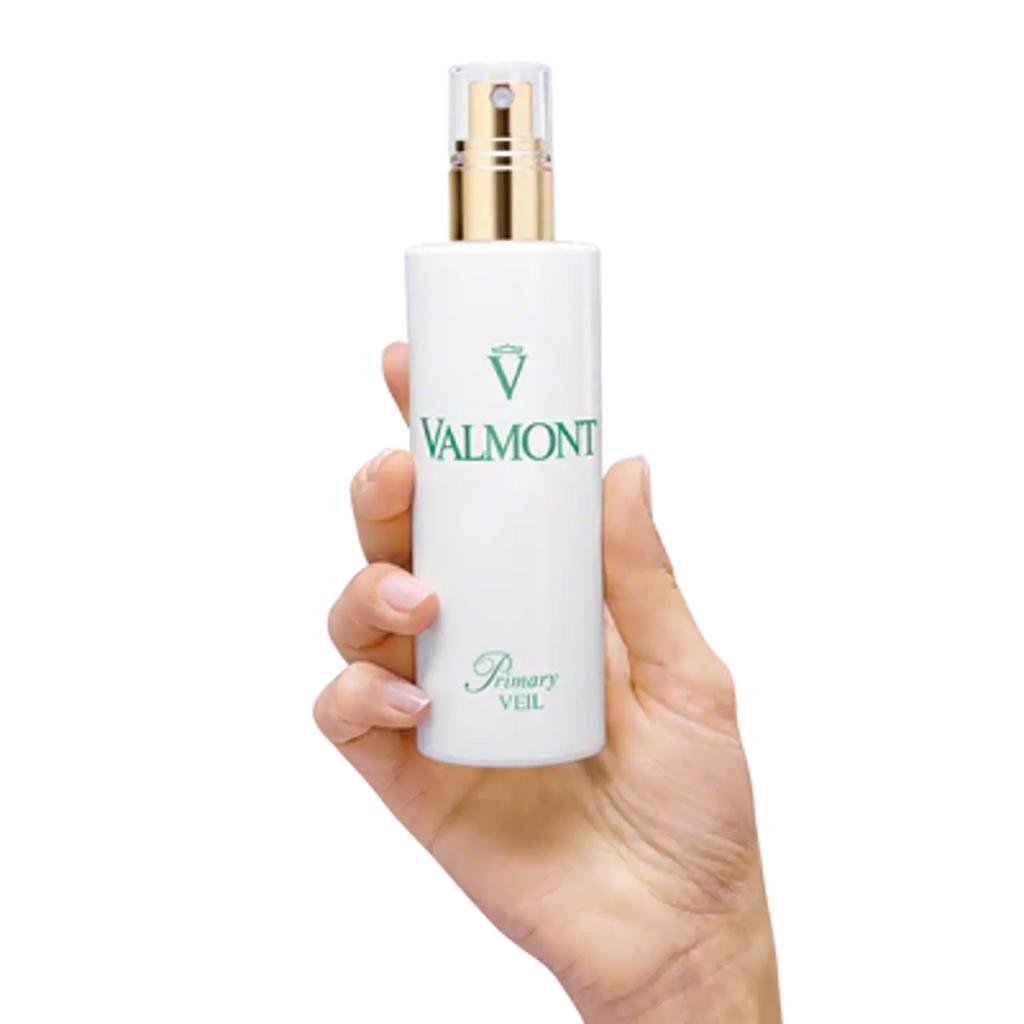 Valmont Primary Veil 150 ml bottle held in hand, gold-toned pump